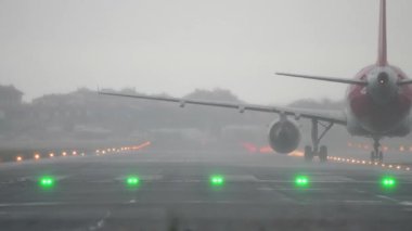 Islak pistte sağanak yağmurda kalkışa hazırlanan uçak görüş mesafesi düşük.