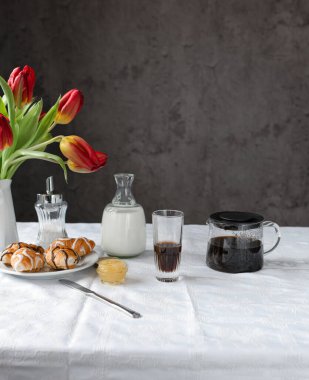 Breakfast with tulips and coffee on the table
