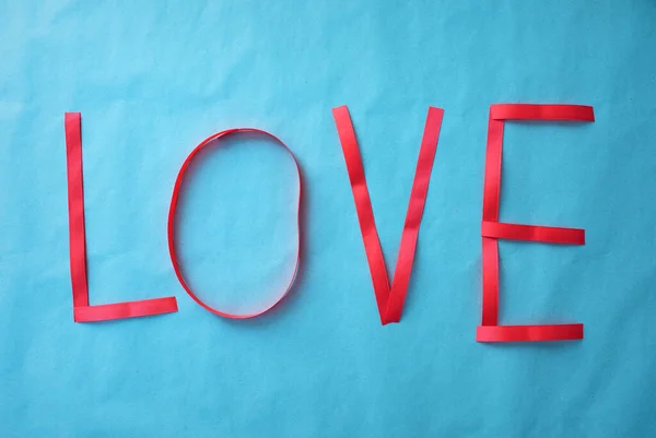 Aşk Kelimesi Mavi Bir Arka Planda Hediye Kurdelesiyle Yazılmış — Stok fotoğraf
