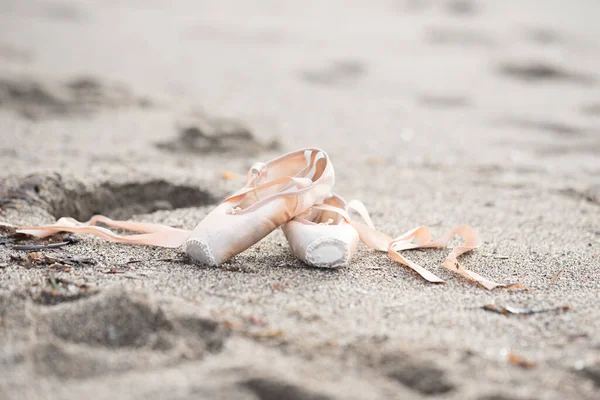 Pointe shoes for ballet. Pointe shoes lie on the sand. Ballet shoes