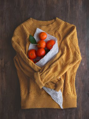 Bir çanta mandalinalı süveter.