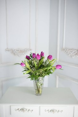 Kristal vazodaki mor laleler retro arka planda.