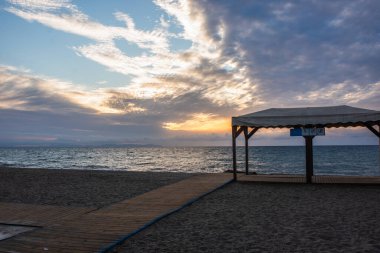 Tahta bir patika, deniz kıyısındaki bir çardağa çıkar.