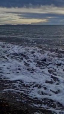 Bulutlu havada denizin dikey fotoğrafı.