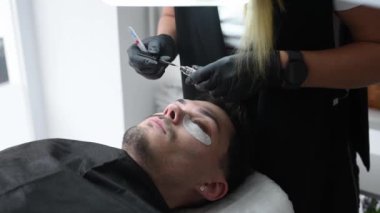Kirpik bakım salonunda genç bir adam.