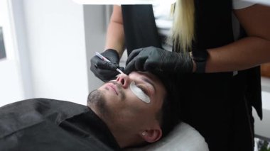 Güzellik salonunda kirpiklerle ilgilenen bir adamın videosu..