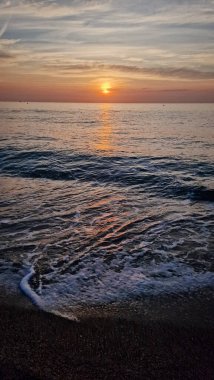 Deniz ve parlak gün doğumu. Konsept - tatil ve seyahat. Dikey fotoğraf.
