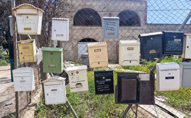 Paslı metal posta kutusu çiçek açan leylak dalları ve bahçe çitlerinde yeşil yapraklarla çevrili, mükemmel bir bahar kırsal ayrıntısı..