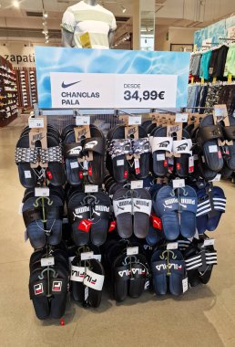 Almerya, İspanya - Haziran 02, 2025: Nike ve Puma parmak arası terlikleri perakende satışta düzgünce düzenlenerek, yaz ayakkabı tercihleri ve fiyatlandırma ayrıntıları vurgulandı