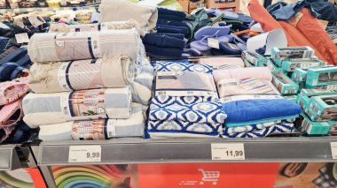 Almerya, İspanya - 25 Mayıs 2025: Renkli havlular ve battaniyeler bir perakende mağazasında sergileniyor, ev dekorasyonu için çeşitli dokular ve desenler vurgulanıyor