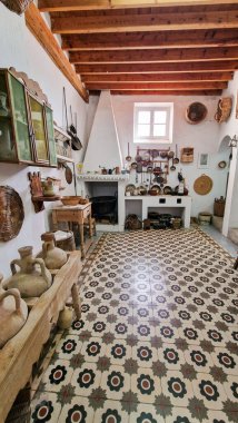 Cozy rustic kitchen with wooden beams, decorative pottery, and patterned tiles, creating a warm ambiance filled with vintage charm and traditional craftsmanship