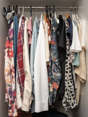 A vibrant collection of clothing is displayed in a closet, featuring various patterns, textures, and colors, perfect for fashion enthusiasts seeking inspiration