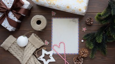 Paketli hediyeler, dekoratif eşyalar ve boş bir not defteri ile tatil temalı düzenleme, festival hazırlıkları için sıcak ve davetkar bir ortam çağrıştırıyor.