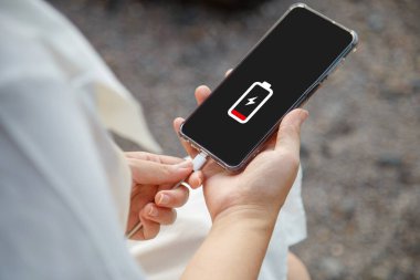 Cep telefonunu şarj eden bir kadının ellerini kapat