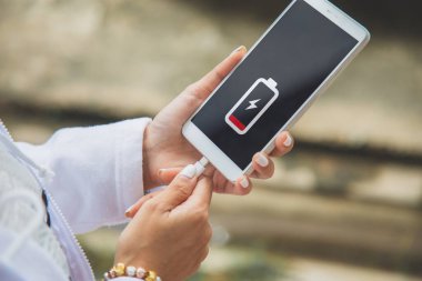 Cep telefonunu şarj eden bir kadının ellerini kapat