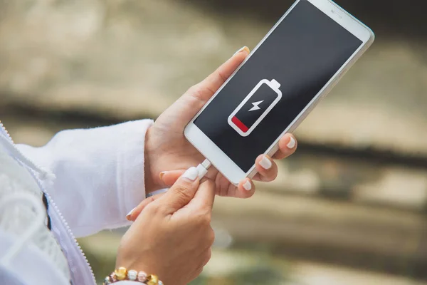 Cep telefonunu şarj eden bir kadının ellerini kapat