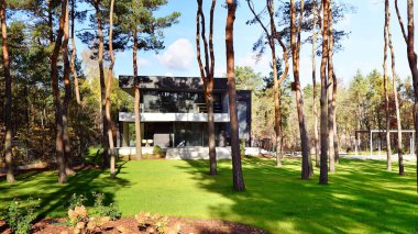 Ormanda büyük bir terası olan modern bir villa. Ormanın ortasında büyük bir konutun modern tasarımı.