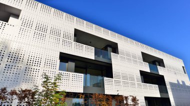 Yeşil yerleşim bölgesinde yeni daireleri olan modern bir yerleşim yeri. Yeşil ağaç ve yeni apartman. Doğanın ve modernliğin ahengi. Daire yeni sakinleri bekliyor..