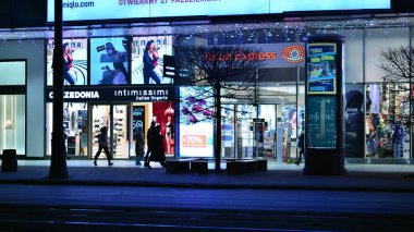 Varşova, Polonya. 23 Kasım 2022. Varşova 'nın merkezinde akşam hayatı. Geceleri Varşova sokaklarında yürüyen insanlar şehir merkezinde gece vakti insanları ve arabaları seçici bir şekilde bulanıklaştırıyor..