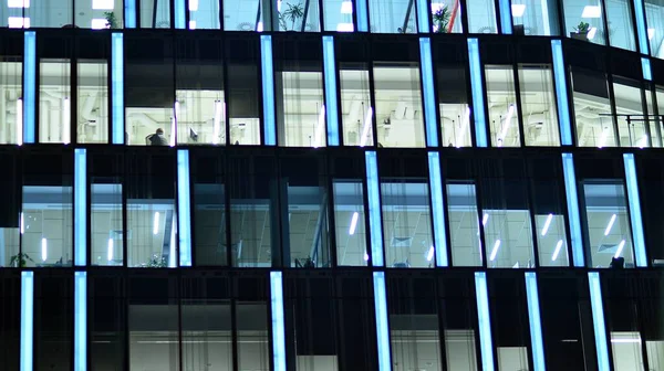 stock image Modern office building in city at the night. View on illuminated offices of a corporate building. Blinking light in window of the multi-storey building of glass and steel. Long exposure at night