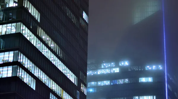 夜市内の近代的なオフィスビル 企業ビルの照明オフィスをご覧ください ガラスと鋼の多階建ての建物の窓に光を点滅させます 夜の長時間露光 — ストック写真