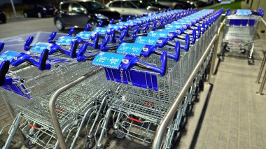 Varşova, Polonya. 29 Kasım 2022. Geceleri Aldi pazarının önünde sıra sıra alışveriş arabaları. Aldi dünya çapında indirimli bir süpermarket.