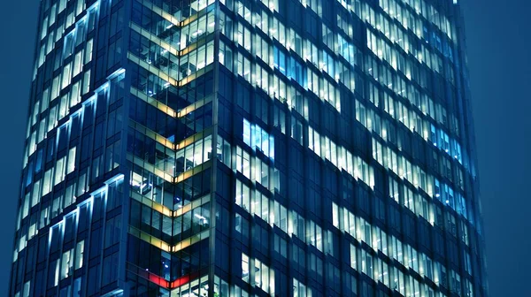 オフィスビルの窓のパターンは夜に点灯します ガラス建築 夜の企業ビル ビジネスコンセプト 青いグラフィックフィルター — ストック写真