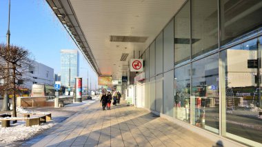 Varşova, Polonya. 14 Aralık 2022. Büyük bir şehrin kış sokağında insanlar sıcak bir şekilde yürür..