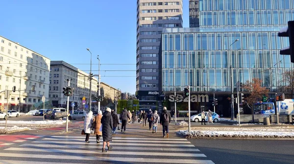 stock image Warsaw, Poland. 14 December 2022. Winter street of a big city. People of different ages crossing the road through. View of a city street with residents, tourists and modern buildings.   