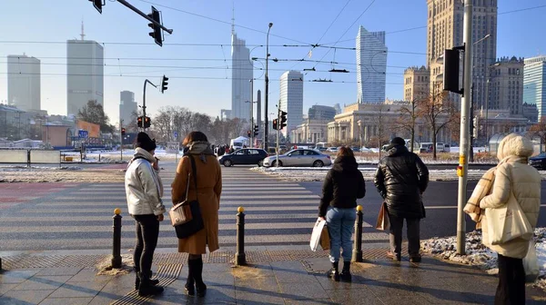 stock image Warsaw, Poland. 14 December 2022. Winter street of a big city. People of different ages crossing the road through. View of a city street with residents, tourists and modern buildings.   