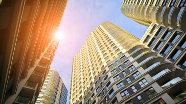 Modern konut binaları arasındaki dar geçit. Yüksek binalardan oluşan duvarlar ve aralarında dar bir gökyüzü şeridi. Modern kentsel yaşam bölgeleri. Alt görünüm.