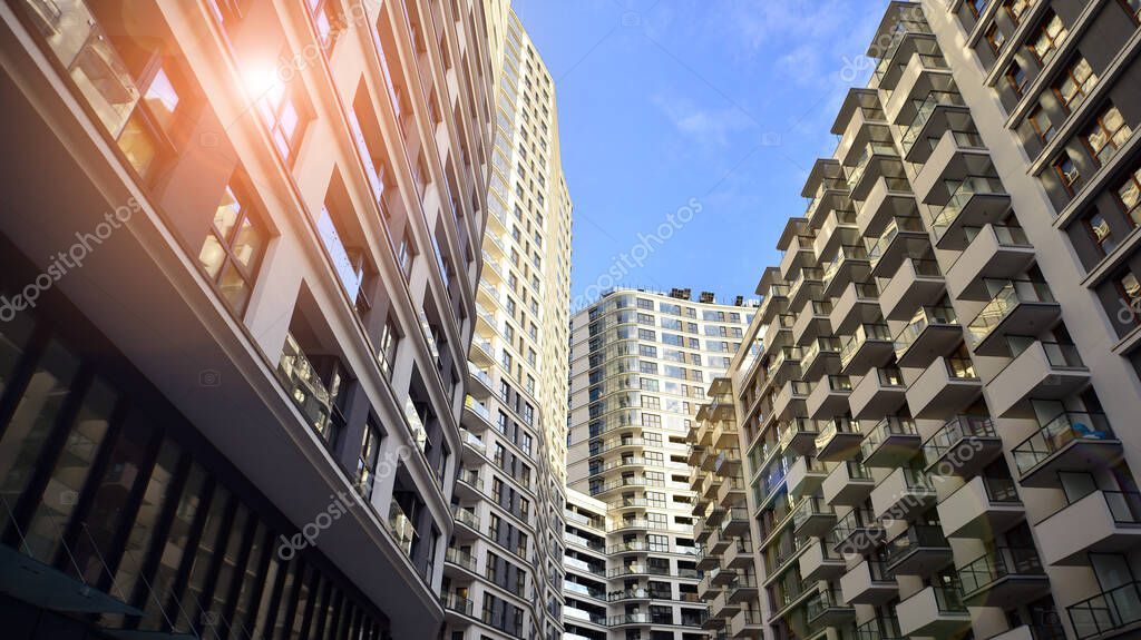 The narrow passage between modern residential buildings. Walls of high