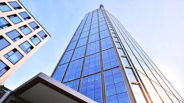 Mavi gökyüzüne karşı modern gökdelenlerin alt manzarası. Şehir merkezindeki iş binalarına bakıyorum..