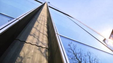 Mavi gökyüzüne karşı modern gökdelenlerin alt manzarası. Şehir merkezindeki iş binalarına bakıyorum..