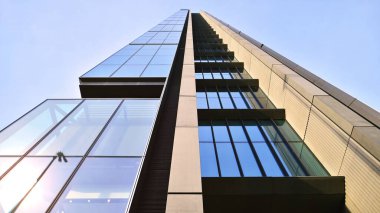 Mavi gökyüzüne karşı modern gökdelenlerin alt manzarası. Şehir merkezindeki iş binalarına bakıyorum..