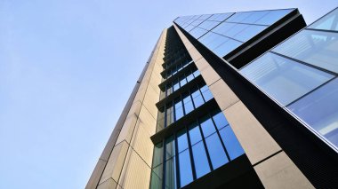 Mavi gökyüzüne karşı modern gökdelenlerin alt manzarası. Şehir merkezindeki iş binalarına bakıyorum..