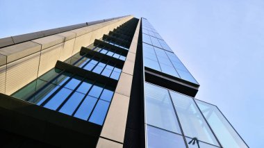 Mavi gökyüzüne karşı modern gökdelenlerin alt manzarası. Şehir merkezindeki iş binalarına bakıyorum..