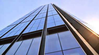 Mavi gökyüzüne karşı modern gökdelenlerin alt manzarası. Şehir merkezindeki iş binalarına bakıyorum..