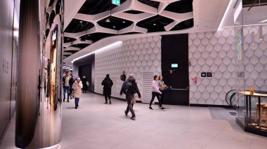 Varşova, Polonya. 8 Mart 2023. Alışveriş merkezinin önünden geçen insanlar. Alışveriş bölümü Varşova HUB. Geniş bir restoran ve mağaza yelpazesi var.. 