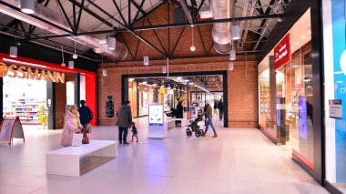 Varşova, Polonya. 8 Mart 2023. Alışveriş merkezinin önünden geçen insanlar. Ferio Wawer önde gelen markaların 40 perakende satış mağazası..