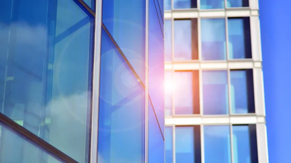 stock image Looking up at the commercial buildings in downtown. Modern office building against blue sky. Windows of a modern glass building.