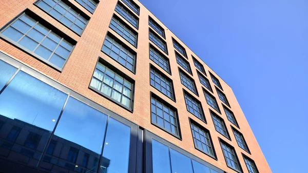 stock image A modern corporate building in the city.  The blue sky is reflected in the buildings large glass windows. Glass facade.