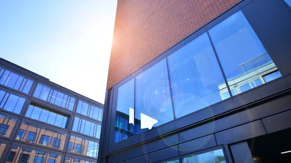 一个现代化的公司建筑在城市里 蓝色的天空反映在建筑物的大玻璃窗上 玻璃立面 — 图库照片