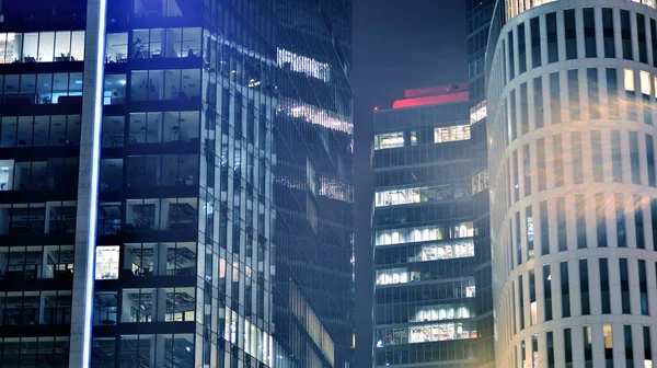 stock image Pattern of office buildings windows illuminated at night. Glass architecture ,corporate building at night - business concept. Blue graphic filter.