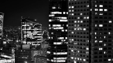 Gece camdan binalar ve modern iş gökdelenleri manzarası. Şehir merkezindeki modern gökdelenlerin ve iş binalarının manzarası. Geceleri büyük şehir. Siyah ve beyaz.