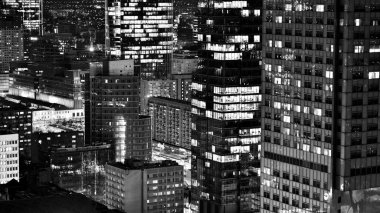 Gece camdan binalar ve modern iş gökdelenleri manzarası. Şehir merkezindeki modern gökdelenlerin ve iş binalarının manzarası. Geceleri büyük şehir. Siyah ve beyaz.