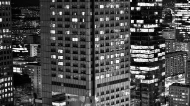 Gece camdan binalar ve modern iş gökdelenleri manzarası. Şehir merkezindeki modern gökdelenlerin ve iş binalarının manzarası. Geceleri büyük şehir. Siyah ve beyaz.