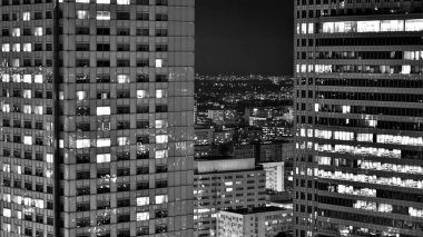 Gece camdan binalar ve modern iş gökdelenleri manzarası. Şehir merkezindeki modern gökdelenlerin ve iş binalarının manzarası. Geceleri büyük şehir. Siyah ve beyaz.