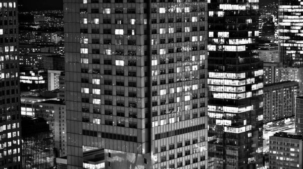View of at night glass buildings and modern business skyscrapers,. View of modern skyscrapers and business buildings in downtown. Big city at night. Black and white.