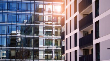 Mavi gökyüzü olan güneşli bir günde modern apartman binaları. Modern bir apartmanın ön cephesi. Gündüz gözüyle çağdaş yerleşim yerinin dış tarafında.. 